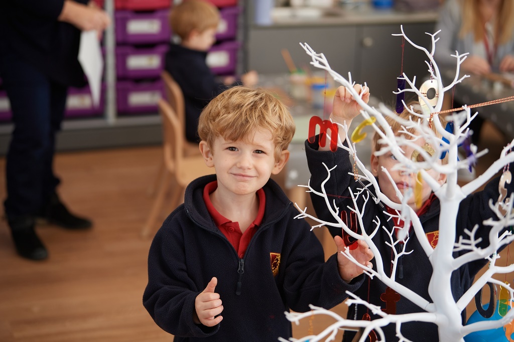 Young male preschool students working on a tree in class