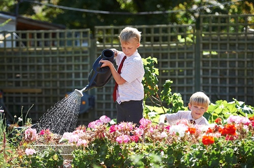 School children watering the flowers outdoors