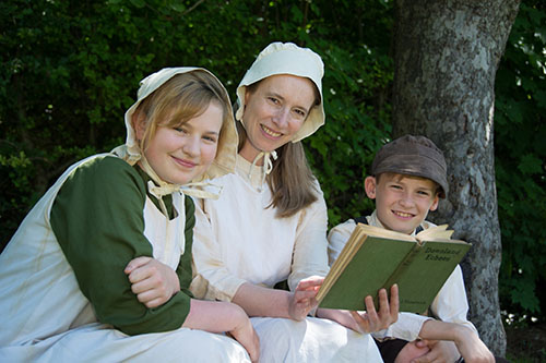 An adult and two students are performing in Lark Rise 