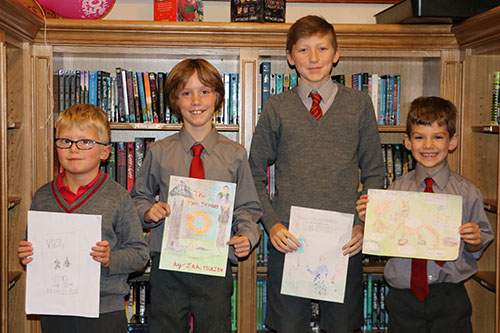 Four students showcasing their drawings at the Travelling Book Fair