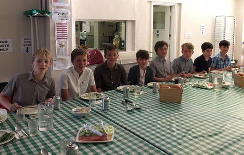 Boarders enjoying a communal supper, fostering friendship and camaraderie in a warm and inclusive atmosphere